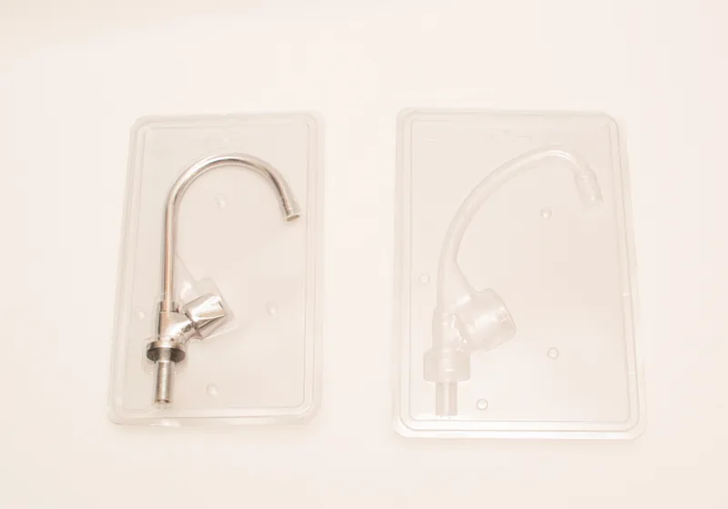 Torneira metálica ao lado do blister plástico transparente feito sob medida para ela